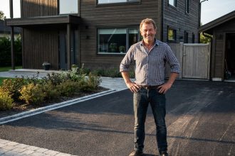 Homme d'âge moyen debout fièrement sur une courbitumineuse neuve