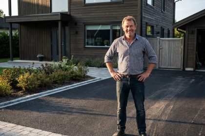 Homme d'âge moyen debout fièrement sur une courbitumineuse neuve